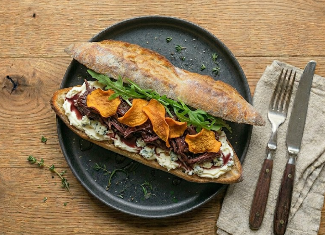 Sandwich L'Aveyronnais — agneau confit au vin rouge, mascarpone au bleu, jus de vin, chips de patate douce.