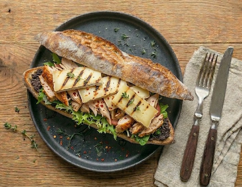 Sandwich Le Basque — poulet rôti au piment d'Espelette, salade, tomates, tomme de brebis grillée, tapenade.
